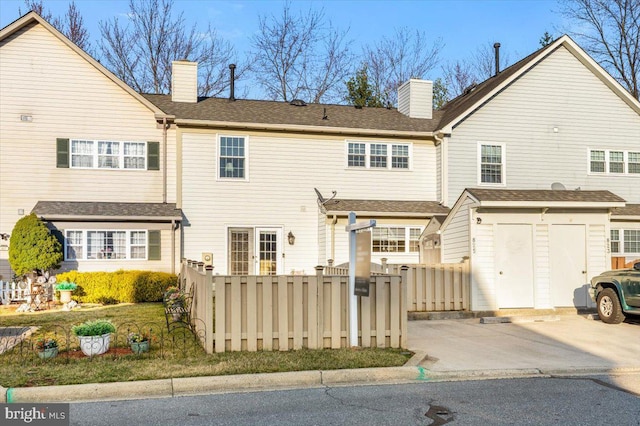 rear view of property with a chimney and fence