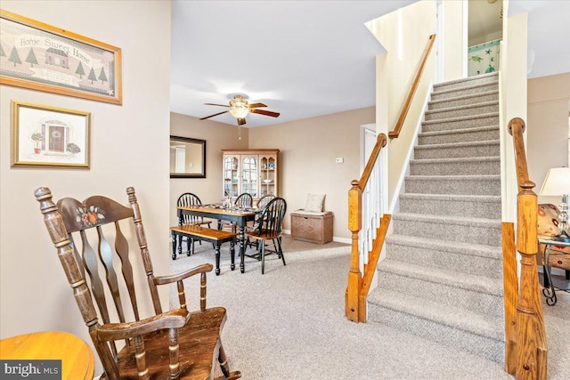 stairs featuring carpet flooring, a ceiling fan, and baseboards