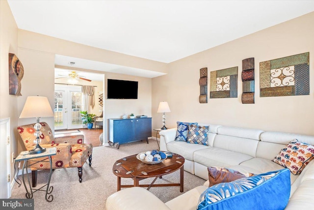 living area with a ceiling fan, carpet flooring, french doors, and visible vents