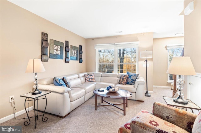 carpeted living area with plenty of natural light, visible vents, and baseboards