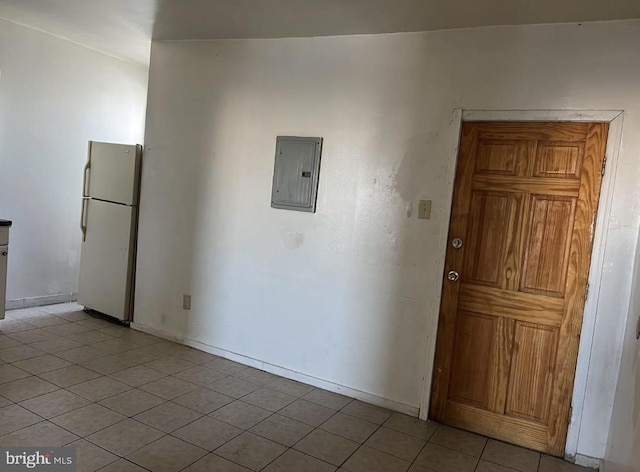 interior space with electric panel, baseboards, and light tile patterned floors