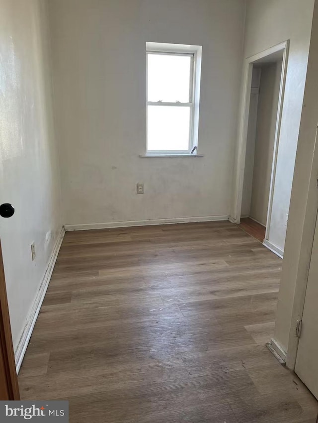 spare room with wood finished floors and baseboards