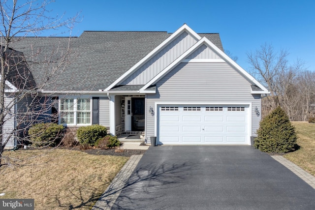 view of front of home with driveway, a shingled roof, board and batten siding, and an attached garage