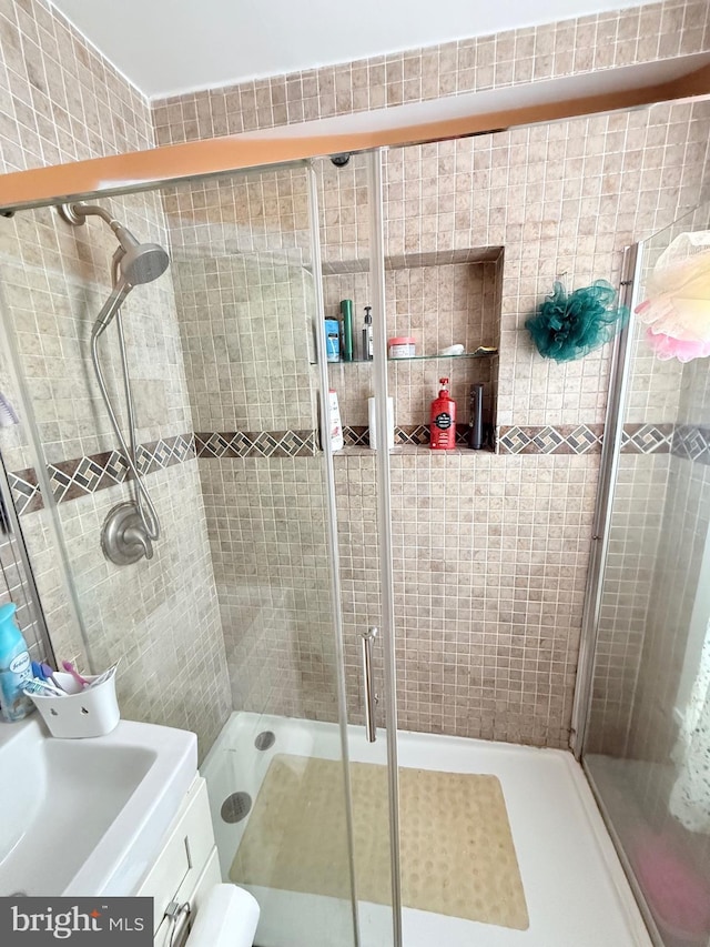 full bath with a stall shower and vanity