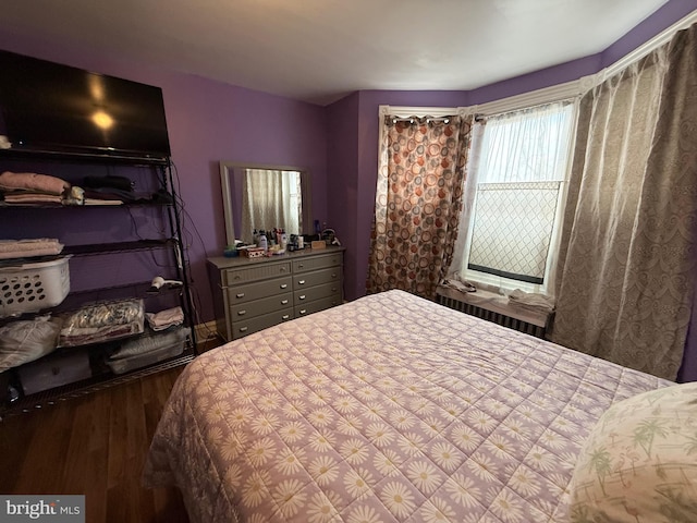 bedroom featuring radiator heating unit and wood finished floors