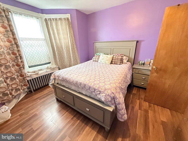 bedroom with radiator and wood finished floors