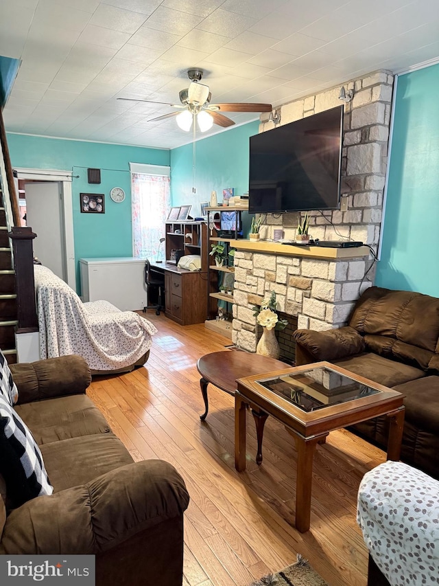 living room featuring stairs, a fireplace, ceiling fan, and hardwood / wood-style flooring