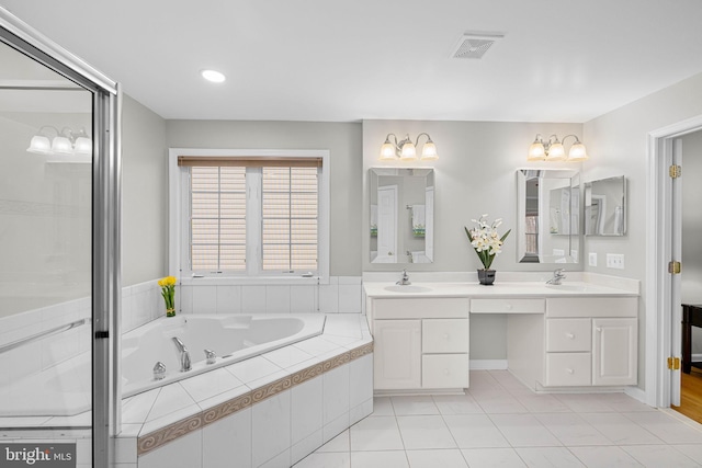 bathroom featuring visible vents, a sink, a whirlpool tub, and double vanity