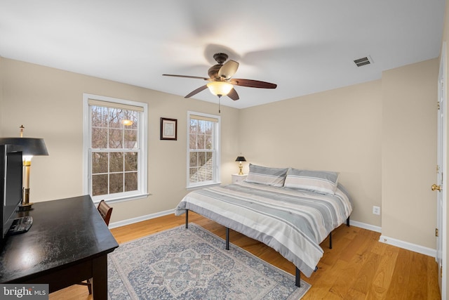 bedroom featuring a ceiling fan, baseboards, visible vents, and light wood finished floors