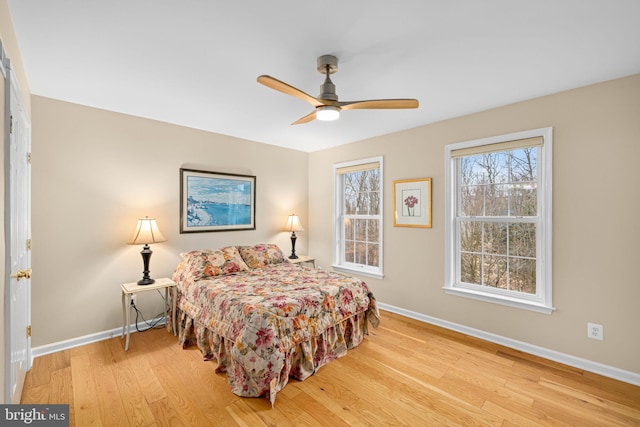 bedroom featuring wood finished floors, a ceiling fan, and baseboards