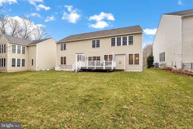 rear view of house with a wooden deck and a yard