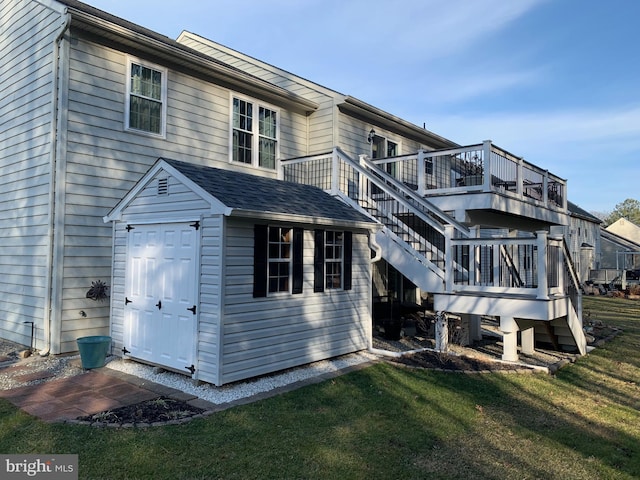 rear view of house with stairs, a lawn, and a wooden deck