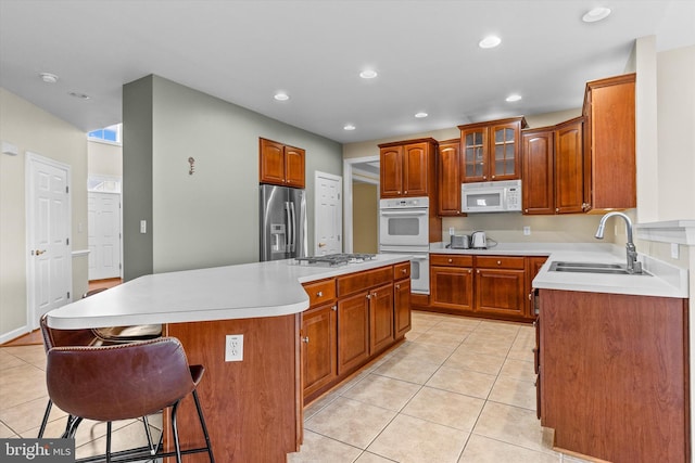 kitchen with a center island, light tile patterned flooring, stainless steel appliances, a sink, and recessed lighting