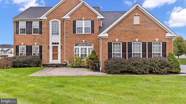 view of front of home featuring a front yard and brick siding