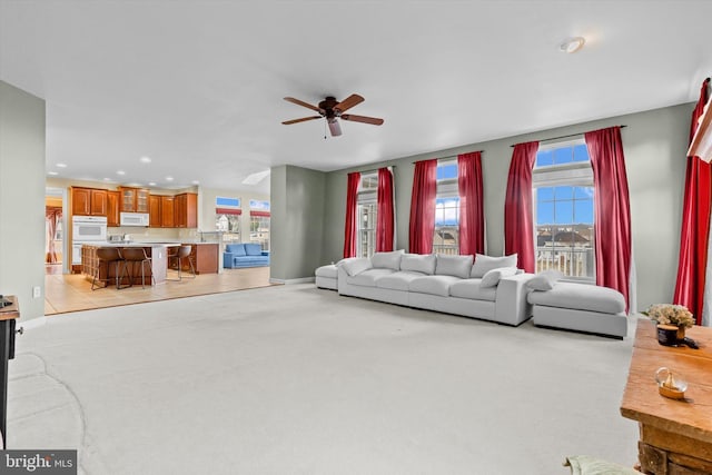 living room with recessed lighting, baseboards, a ceiling fan, and light colored carpet