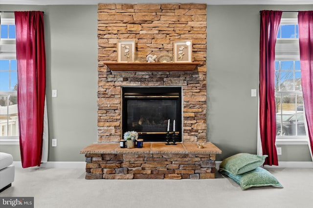 details with a stone fireplace, carpet, and baseboards