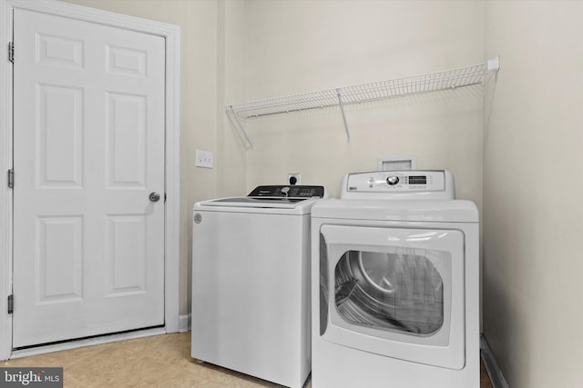 laundry room featuring laundry area, light tile patterned flooring, and washing machine and clothes dryer