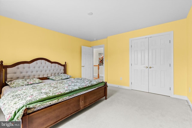 bedroom with light carpet, a closet, and baseboards