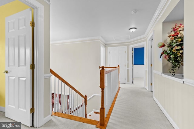 hall with baseboards, carpet floors, an upstairs landing, and crown molding