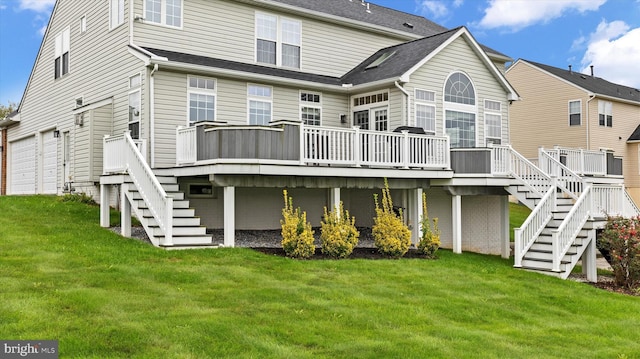 rear view of house featuring a garage, a yard, stairway, and a deck