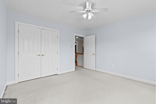 unfurnished bedroom with carpet, a closet, ceiling fan, and baseboards