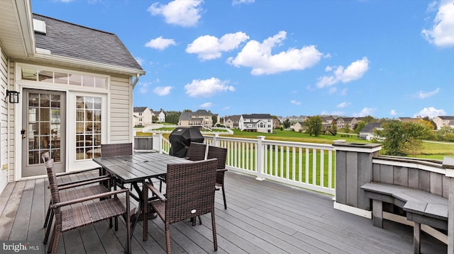 wooden terrace featuring a residential view, a yard, grilling area, and outdoor dining space