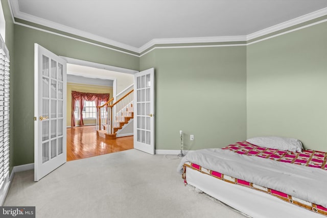 bedroom with baseboards, carpet floors, french doors, and crown molding