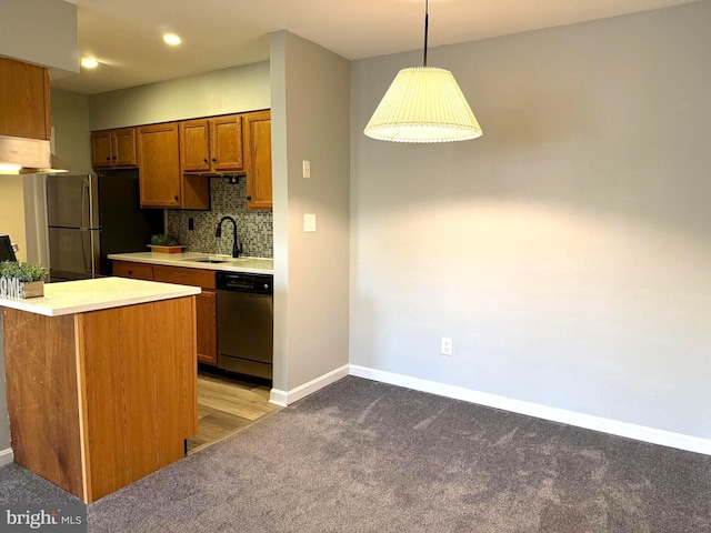 kitchen with decorative backsplash, appliances with stainless steel finishes, brown cabinets, light countertops, and a sink