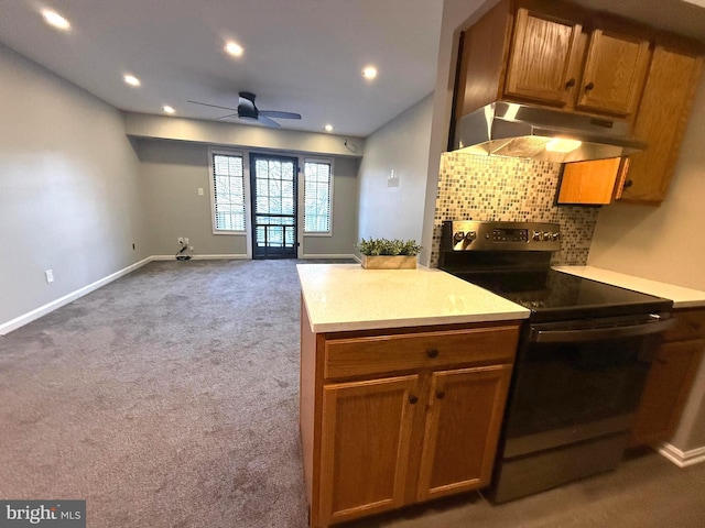 kitchen featuring carpet floors, light countertops, backsplash, stainless steel range with electric cooktop, and under cabinet range hood