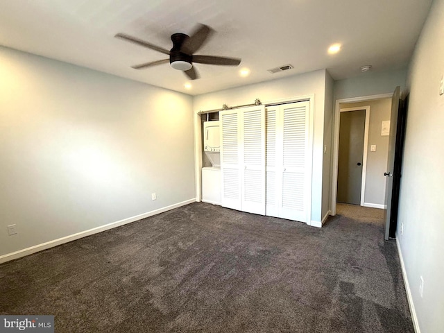 unfurnished bedroom with baseboards, dark carpet, and a closet