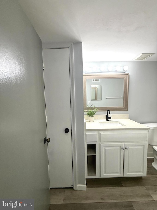 bathroom featuring wood tiled floor, visible vents, vanity, and toilet