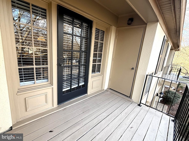 entrance to property with a balcony and stucco siding