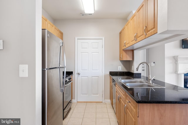 kitchen with visible vents, a sink, stainless steel appliances, dark stone counters, and light tile patterned flooring