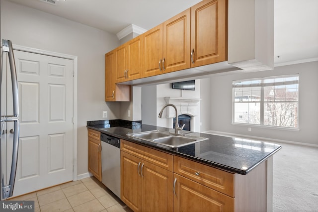 kitchen featuring light tile patterned floors, appliances with stainless steel finishes, a fireplace, a peninsula, and a sink