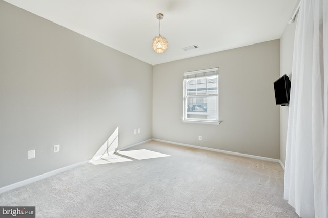 carpeted empty room with visible vents and baseboards