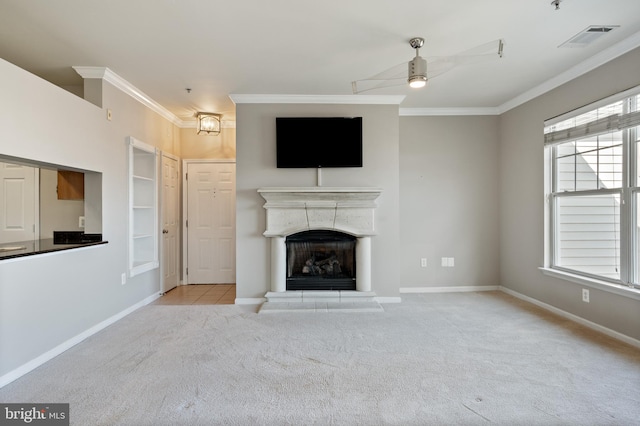 unfurnished living room with a healthy amount of sunlight, a fireplace with raised hearth, carpet flooring, and crown molding