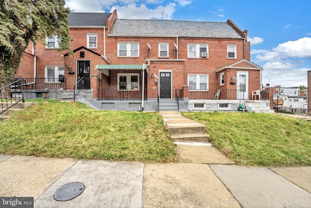 view of property with brick siding, a front lawn, and a high end roof