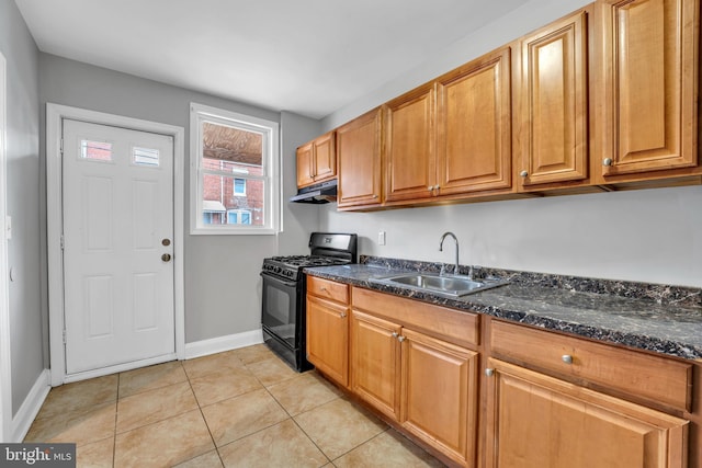 kitchen featuring brown cabinets, light tile patterned floors, gas stove, a sink, and under cabinet range hood