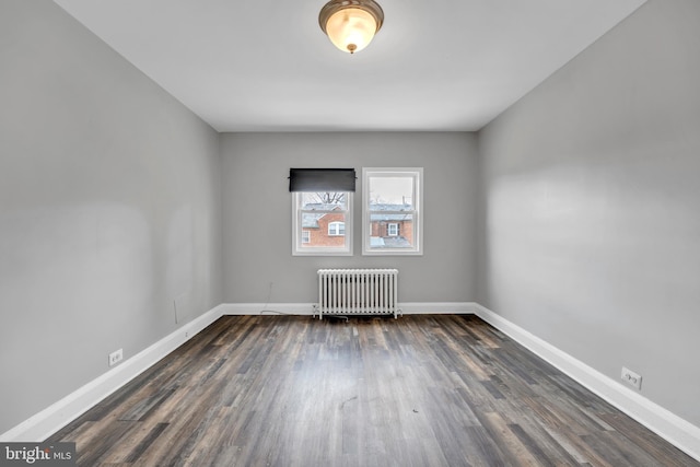 unfurnished room with dark wood-style floors, radiator, and baseboards