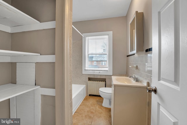 bathroom featuring toilet, tile walls, vanity, tile patterned floors, and radiator