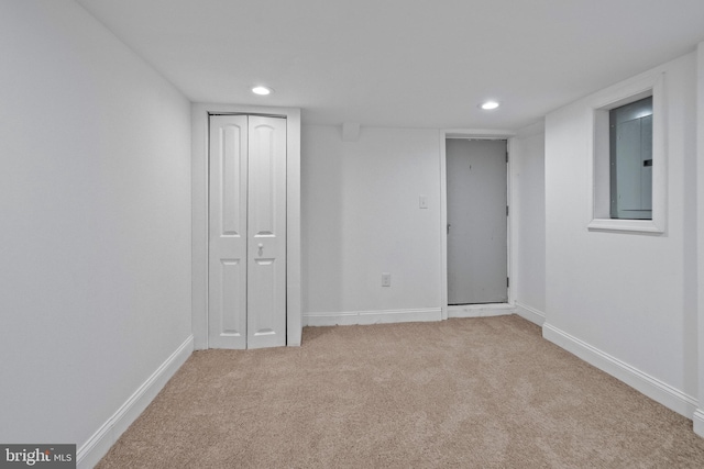 interior space with electric panel, light colored carpet, recessed lighting, and baseboards