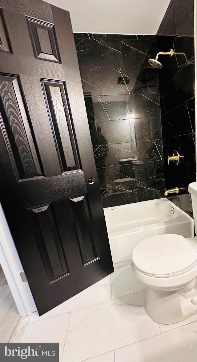 bathroom with washtub / shower combination, marble finish floor, and toilet