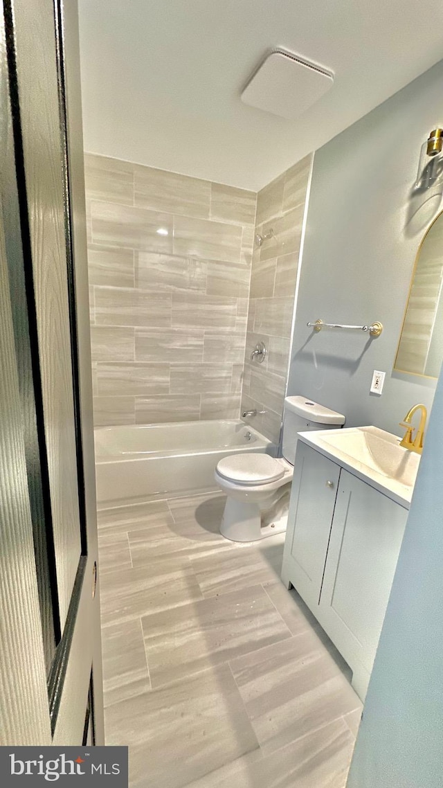 bathroom featuring bathtub / shower combination, vanity, and toilet