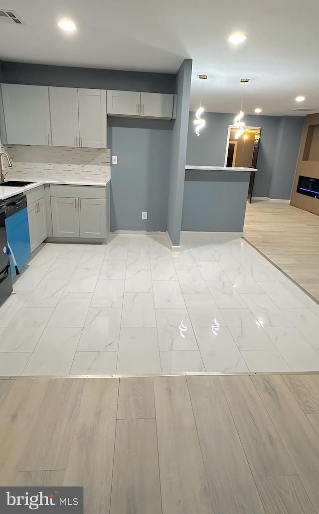 kitchen with visible vents, dishwashing machine, marble finish floor, gray cabinets, and a sink