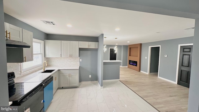 kitchen with visible vents, dishwasher, black electric range, under cabinet range hood, and a sink