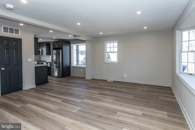 unfurnished living room featuring recessed lighting, visible vents, plenty of natural light, and wood finished floors