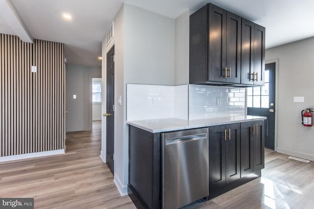 kitchen with light wood finished floors, baseboards, decorative backsplash, and stainless steel dishwasher