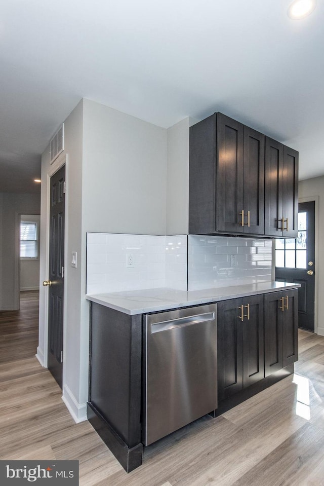 kitchen with tasteful backsplash, visible vents, dishwasher, light countertops, and light wood-style floors