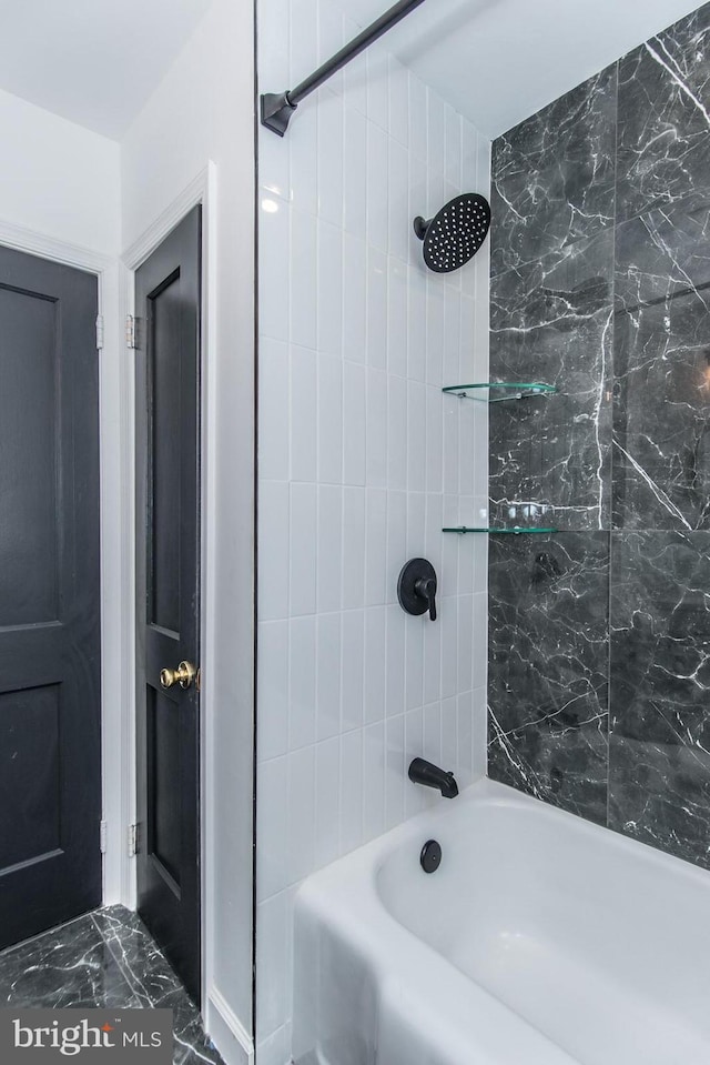 full bathroom featuring marble finish floor and bathing tub / shower combination