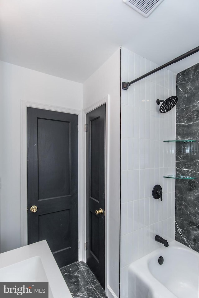 full bath featuring marble finish floor, washtub / shower combination, and visible vents